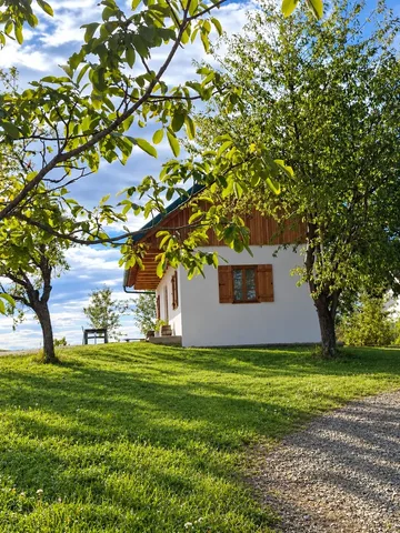 Ferienhaus zwischen Obstbäumen mit Wiese und Kiesweg